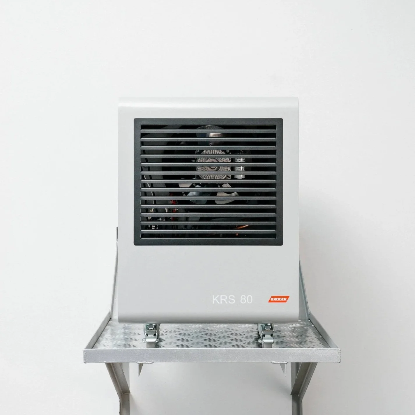 A compact, silver Kruger industrial dehumidifier labeled 'KRS 80' on a metal stand against a white wall.