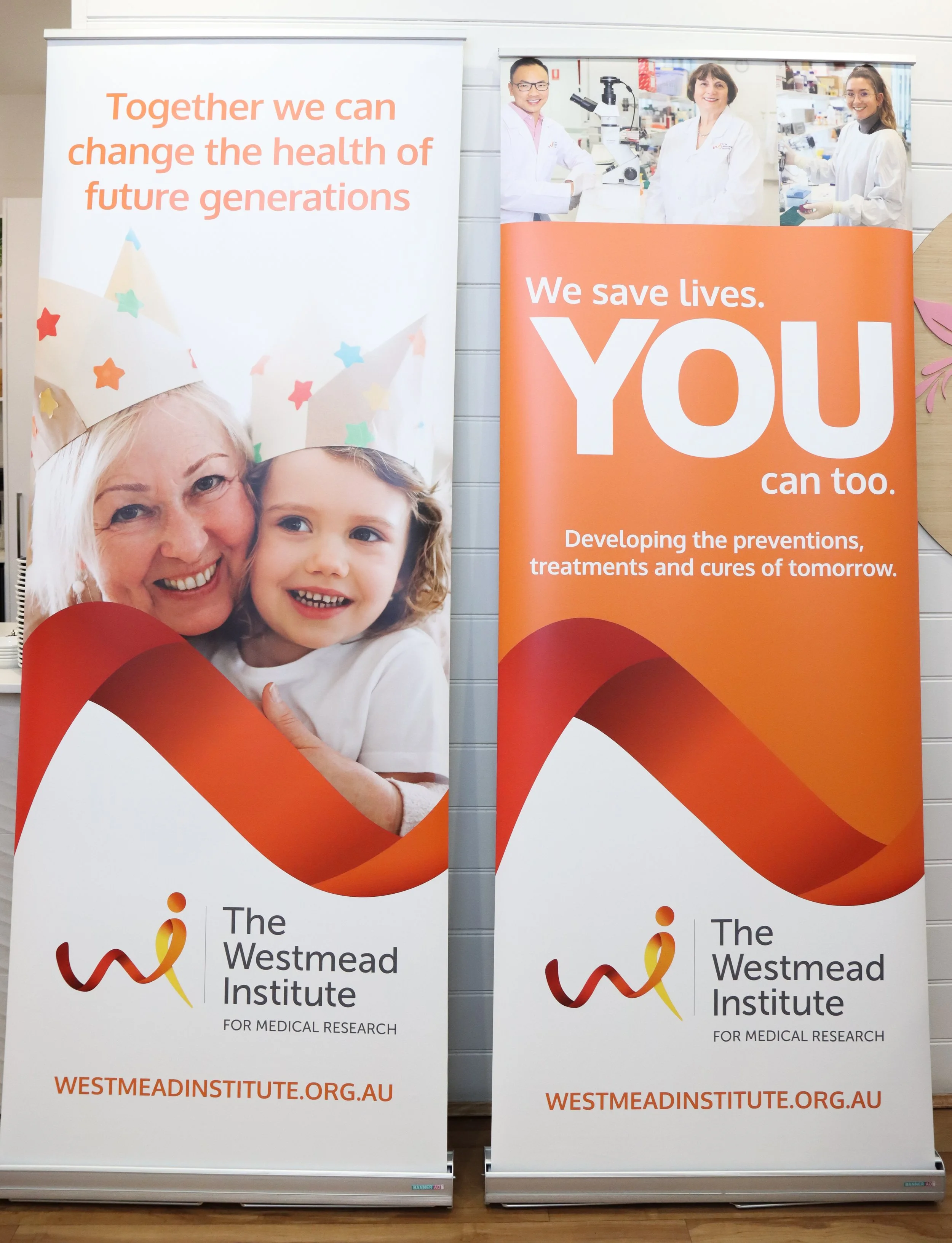 Two vertical banners promoting The Westmead Institute for Medical Research with messages about health and saving lives, featuring images of children and medical professionals.
