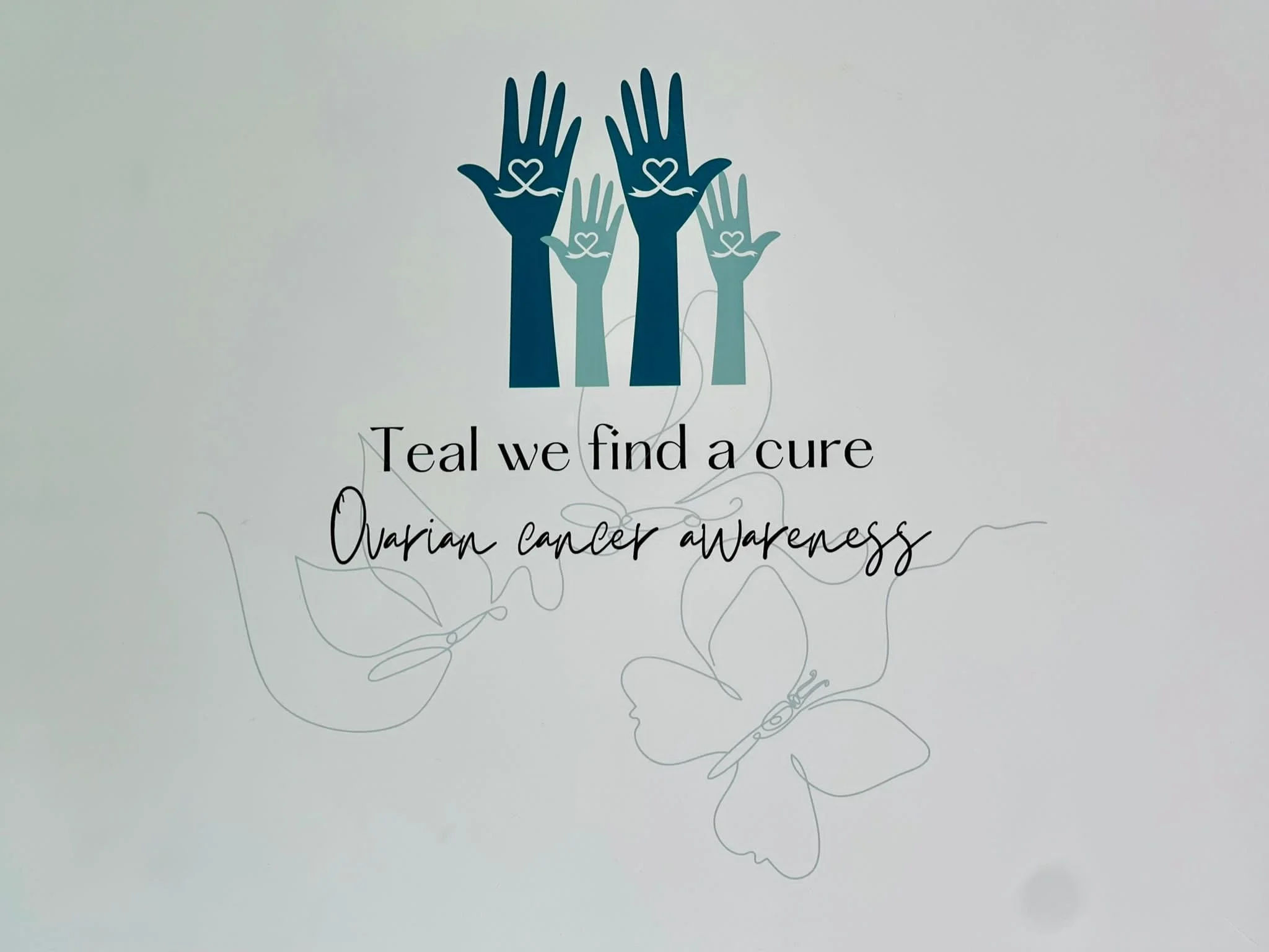 Illustration of five raised blue and light blue hands with heart symbols on the palms. Text reads: 'Teal we find a cure. Ovarian cancer awareness.'