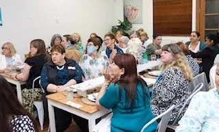 Group of women attending a meeting or conference in a classroom setting.