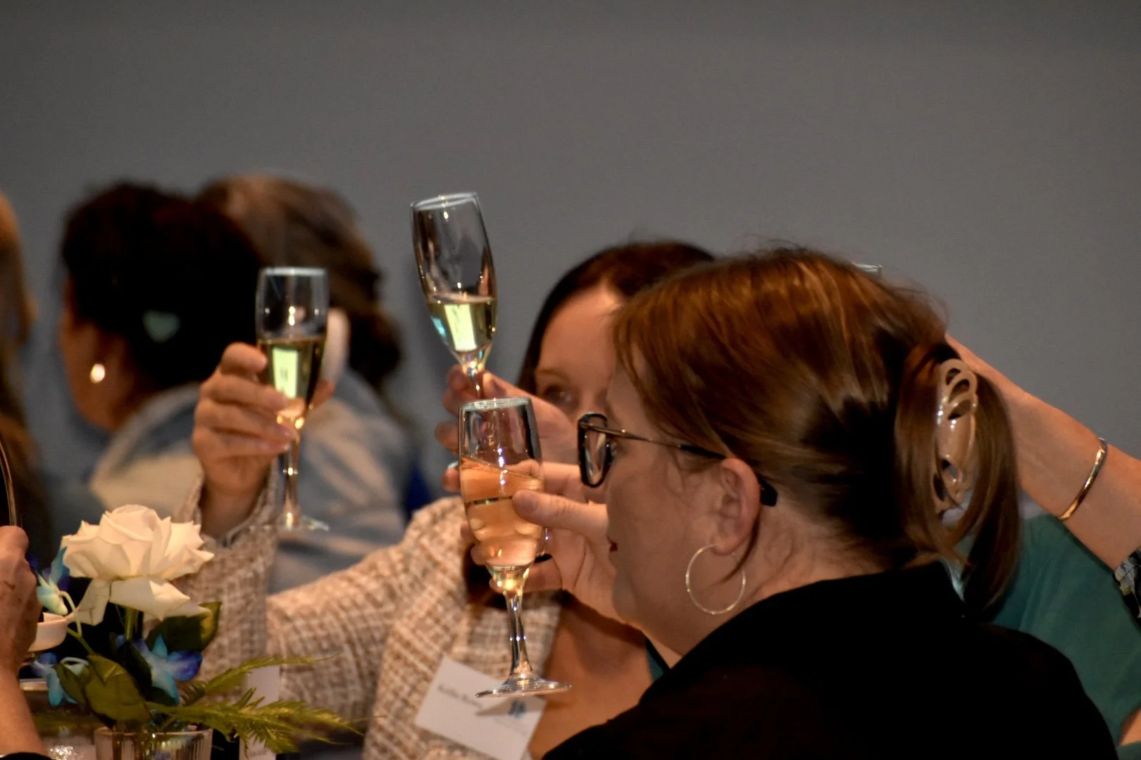 Women celebrating with glasses of champagne at a gathering or event.