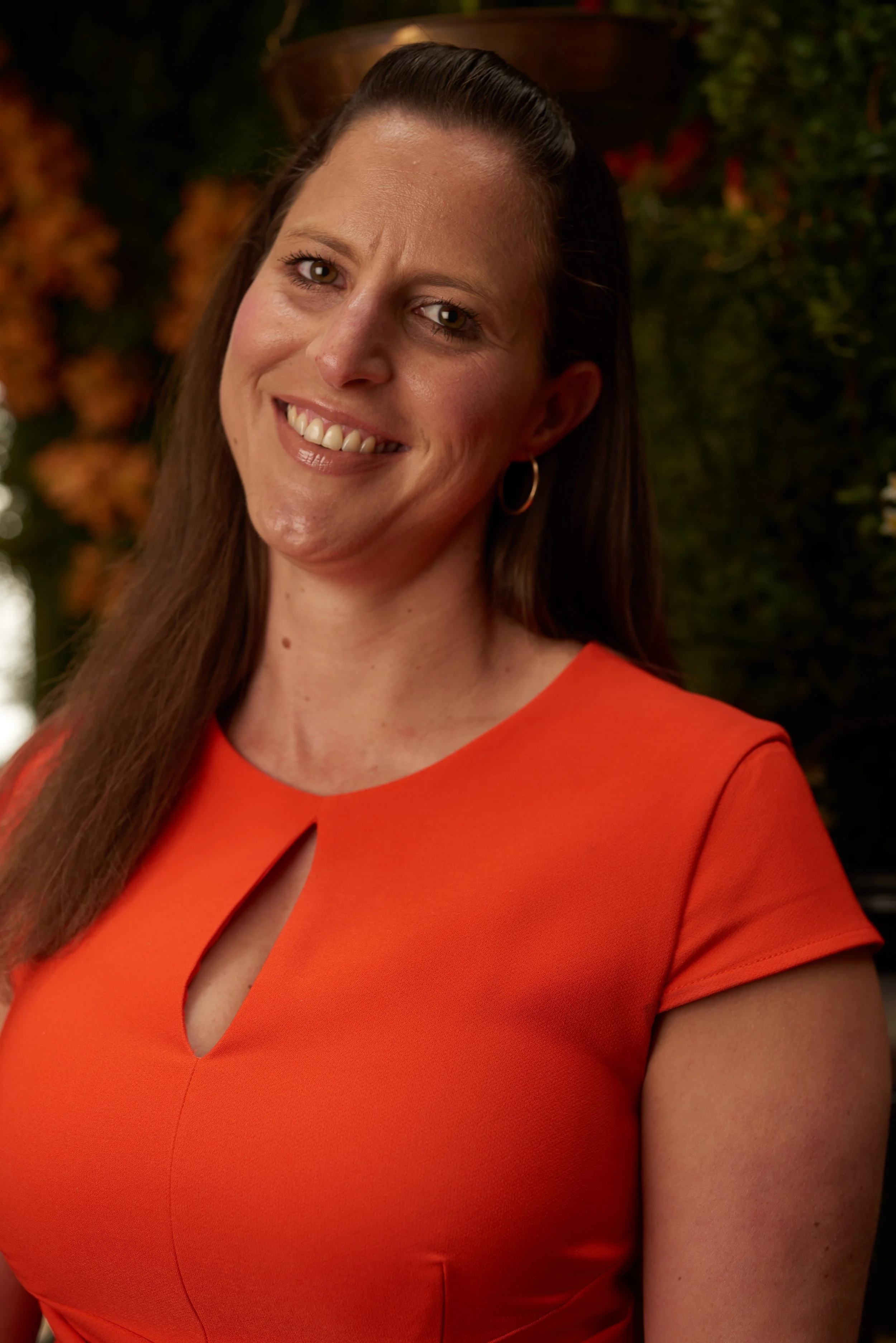 Professional headshot of Nikki Taylor, HR consultant, career coach, and author of “Is This It?”, smiling indoors against a floral backdrop.