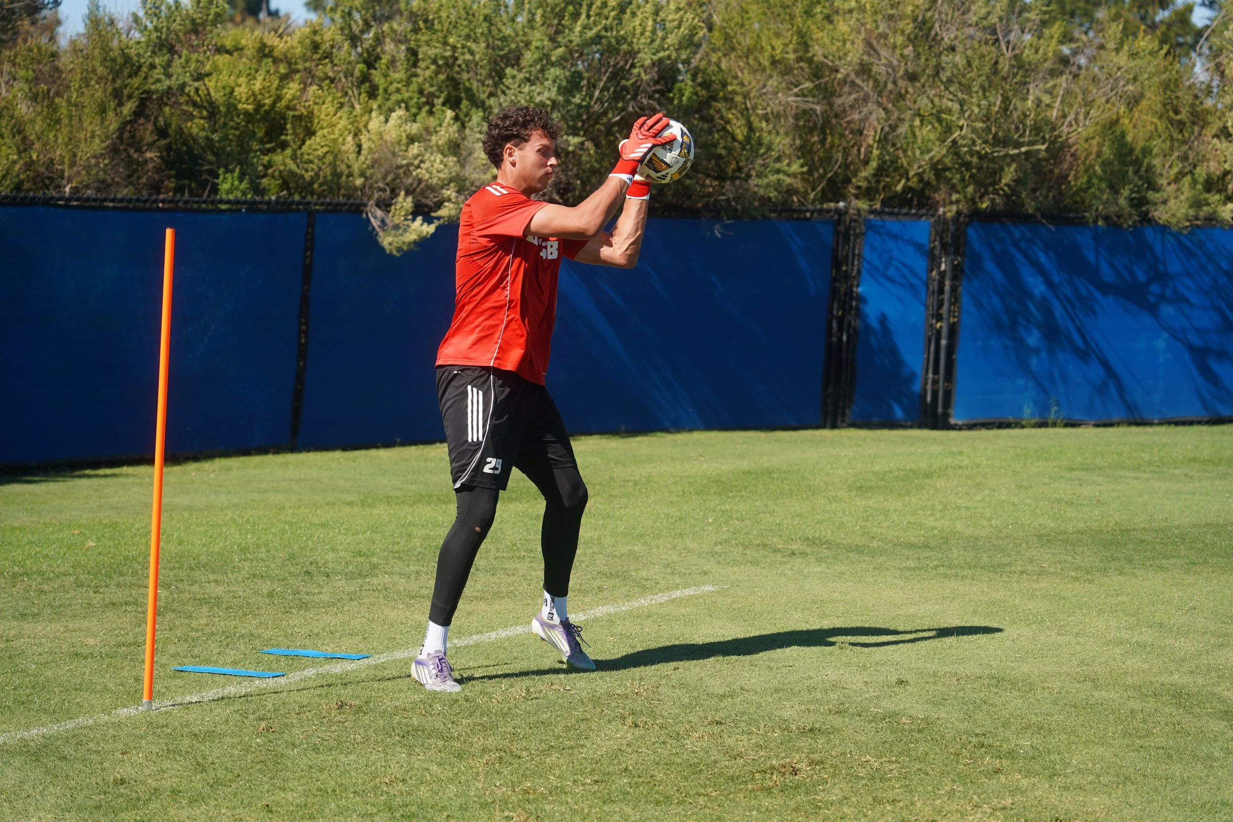 Owen Beninga exemplifying quick reflexes and precision, securing the ball during training session, a moment that demands just as much timing and anticipation from behind the camera as it does from the player on the field