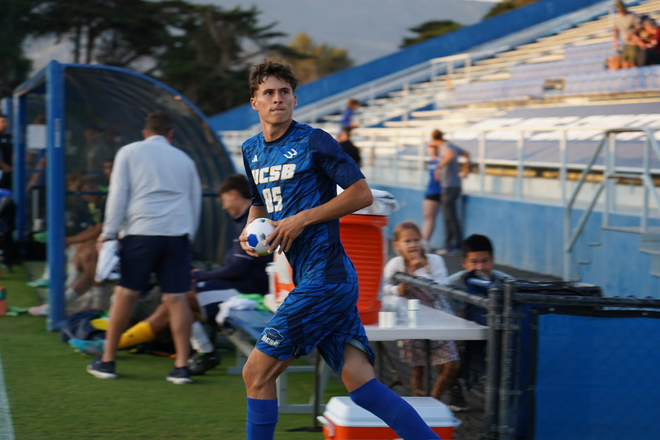 Thomas Noordegraaf charging onto the field as the Gauchos’ starting lineup is announced, ready for kickoff, showing the challenge of timing focus is only on him.
