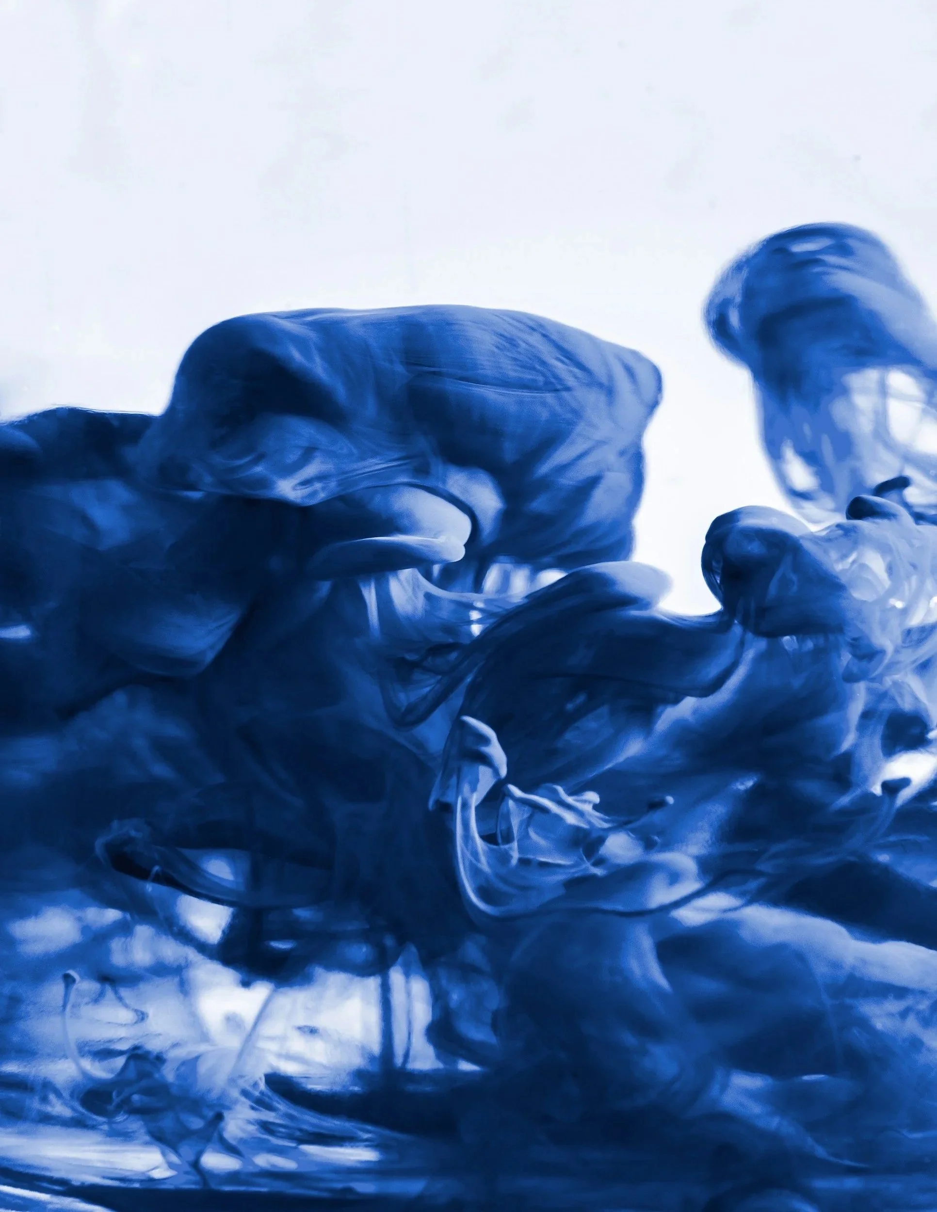 Blau-weiße Tinte oder Farben werden im Wasser verteilt und erzeugen gewellte, spiralförmige Muster.