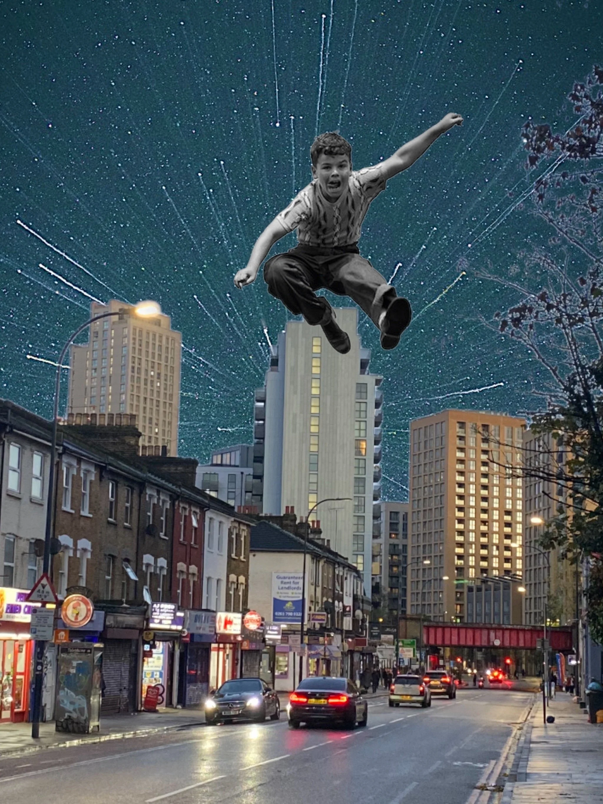 Citystreet scene at dusk with buildings, cars, and storefronts. The sky is edited to show a starry background with a boy jumping or falling in the foreground.