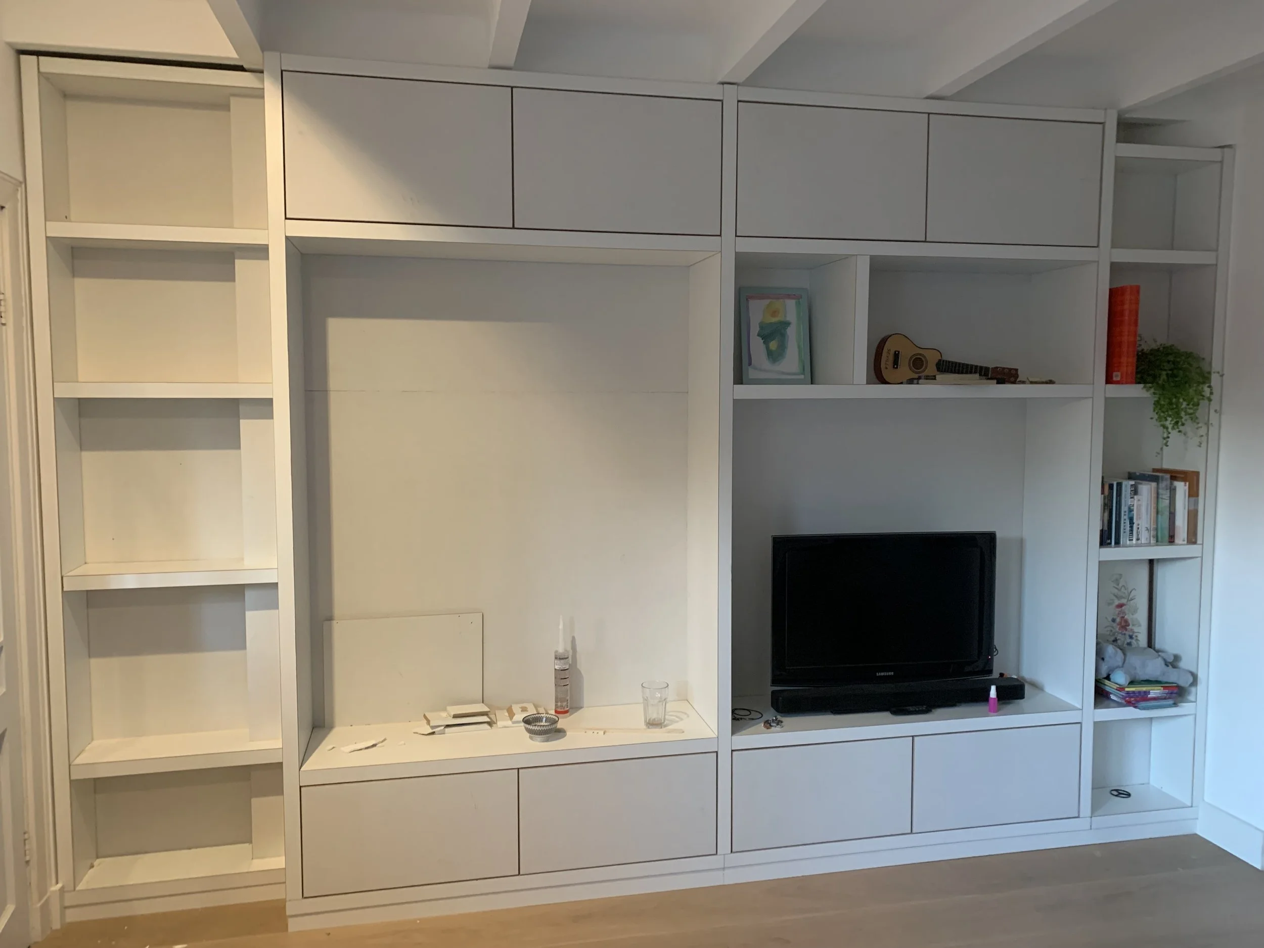 Maatwerk wandmeubel gemaakt van mdf met lakdraagfolie. Onder lades, boven deurtjes verder open vakken. Klant heeft deze zelf geschilderd