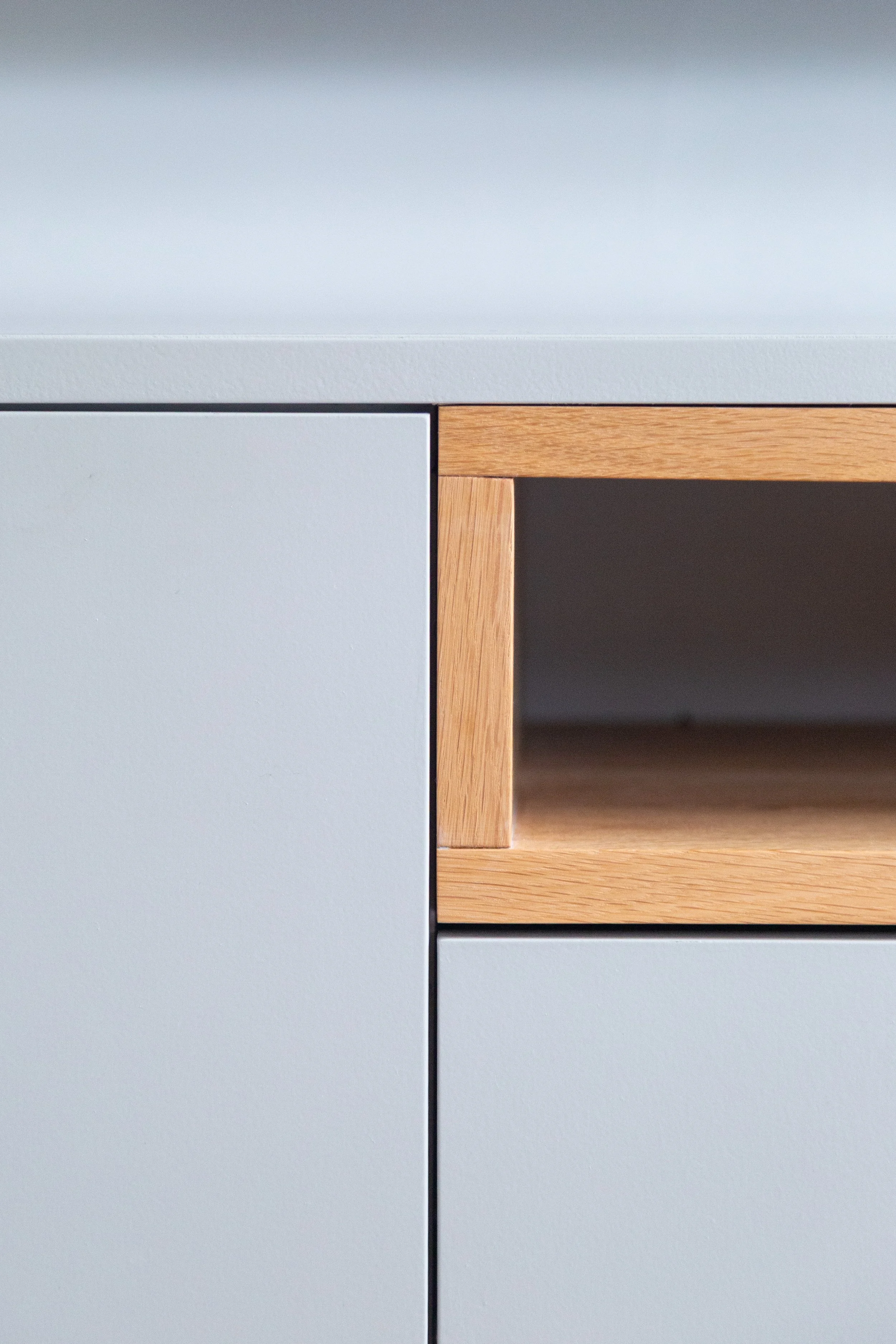Close-up van een tv-meubel met lade met een open vak van eikenhout. Gemaakt in gelakt mdf met 3 softclose lades.