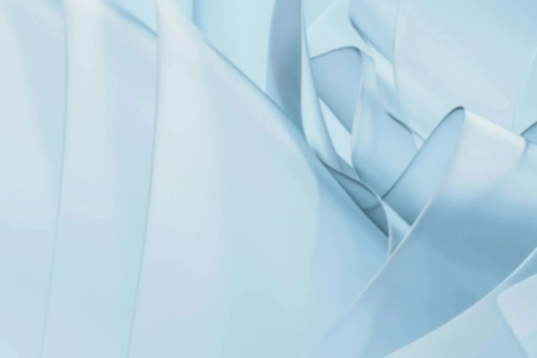 Close-up view of a geometric, abstract background with folded metallic-looking surfaces in shades of white and light blue.