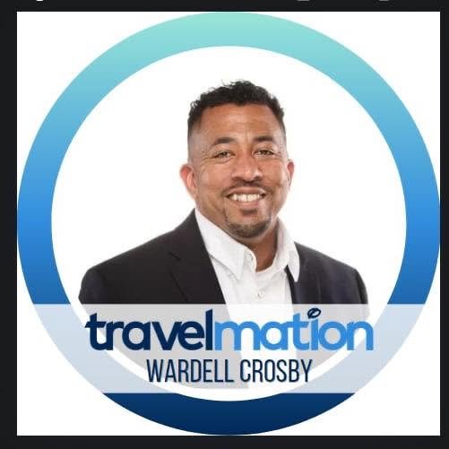 A man in a suit smiling at the camera, with a travel-related logo and text that reads "TravelMation" and "Wardell Crosby" in the background.