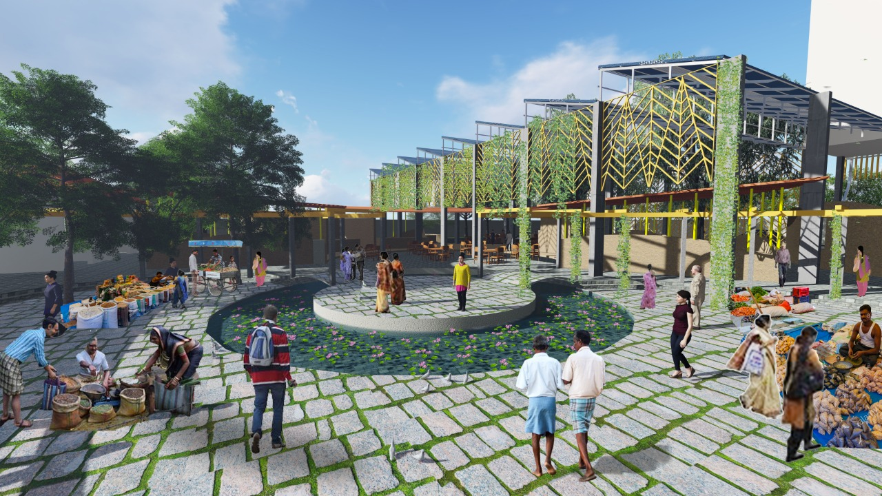 A colorful outdoor marketplace with people shopping and walking around, with a modern building featuring decorative metalwork and greenery in the background, set on a paved area with trees and flower beds.