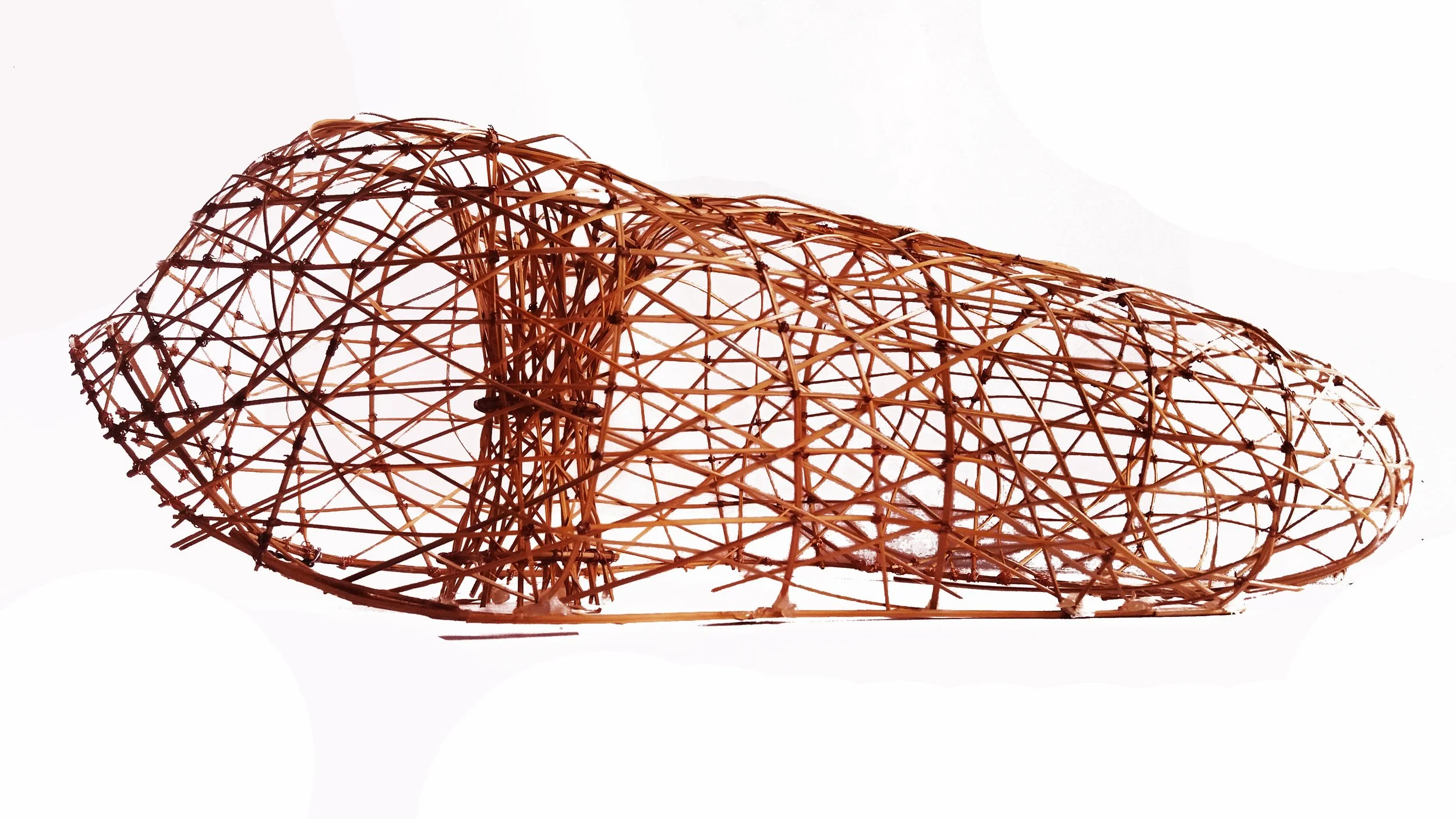 A woven wicker basket modeled in the shape of a shoe, displayed against a white background.