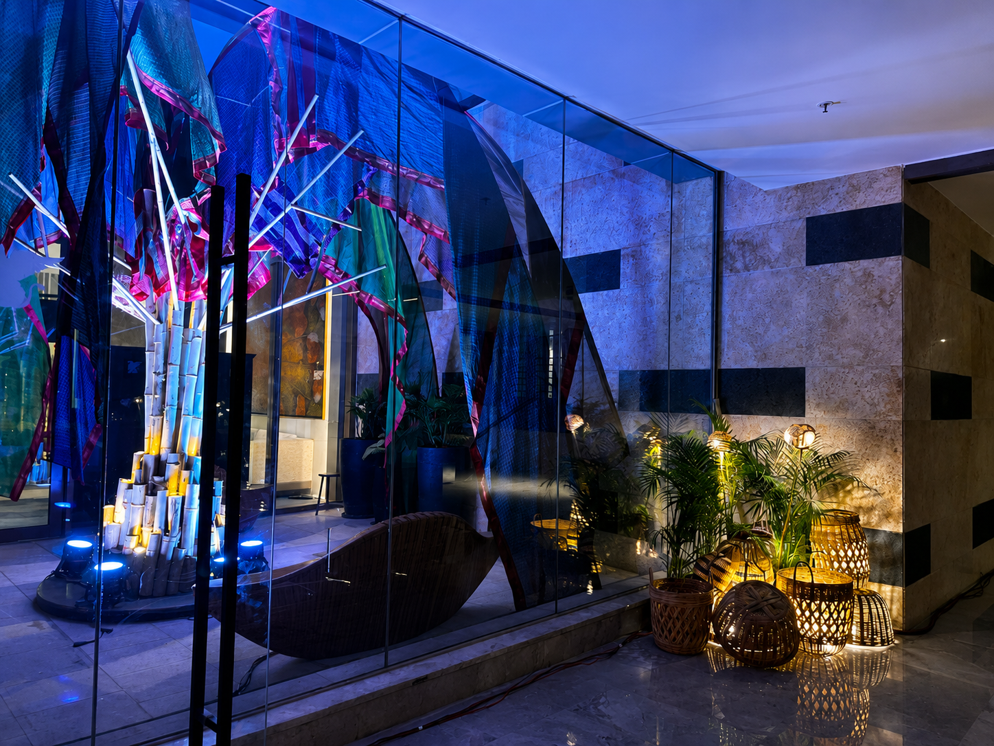 Colorful stained glass window installation with plants and wicker lamps in a modern interior.
