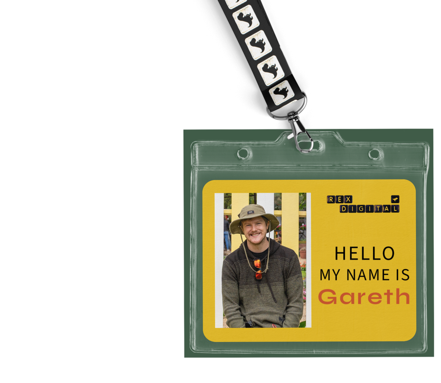 A photo ID badge with a strap featuring black and white cat icons. The badge has a yellow background with a photo of a smiling man wearing a hat and dark clothing. The text on the badge says "HELLO MY NAME IS Gareth," with Gareth in red. The badge also has black initials "REX DIGITAL" at the top right.