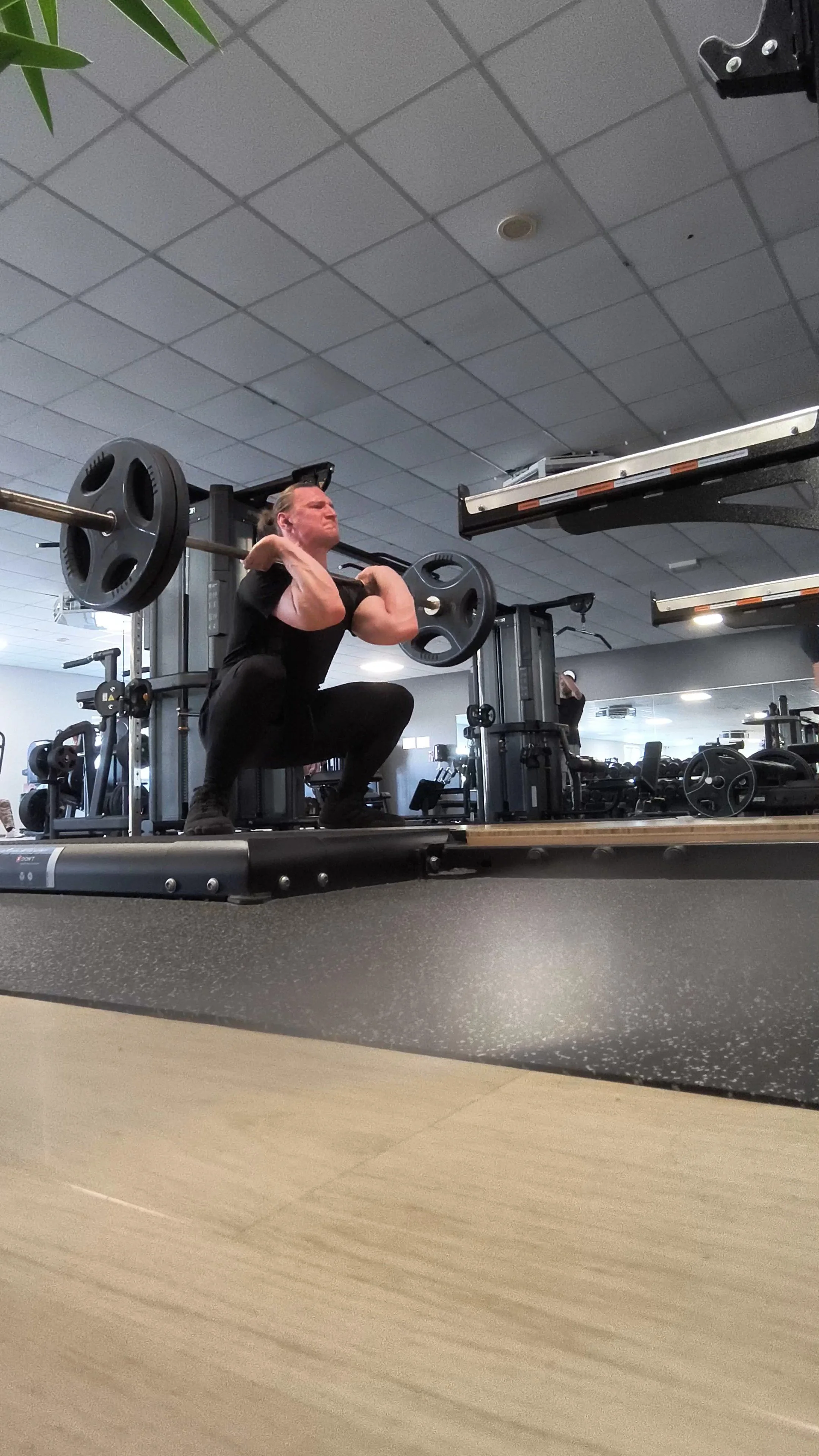 Ein Mann in einem Fitnessstudio macht Bodybuilding-Übungen mit einer Langhantel.