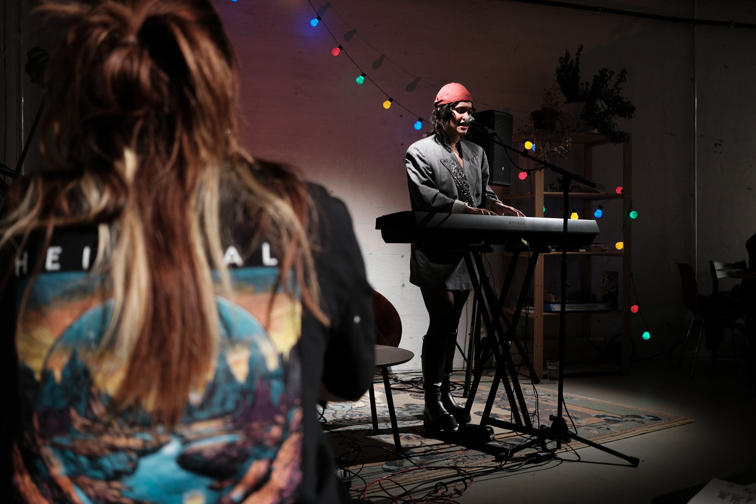 A singer playing the keyboard during a concert in cozy atmosphere.