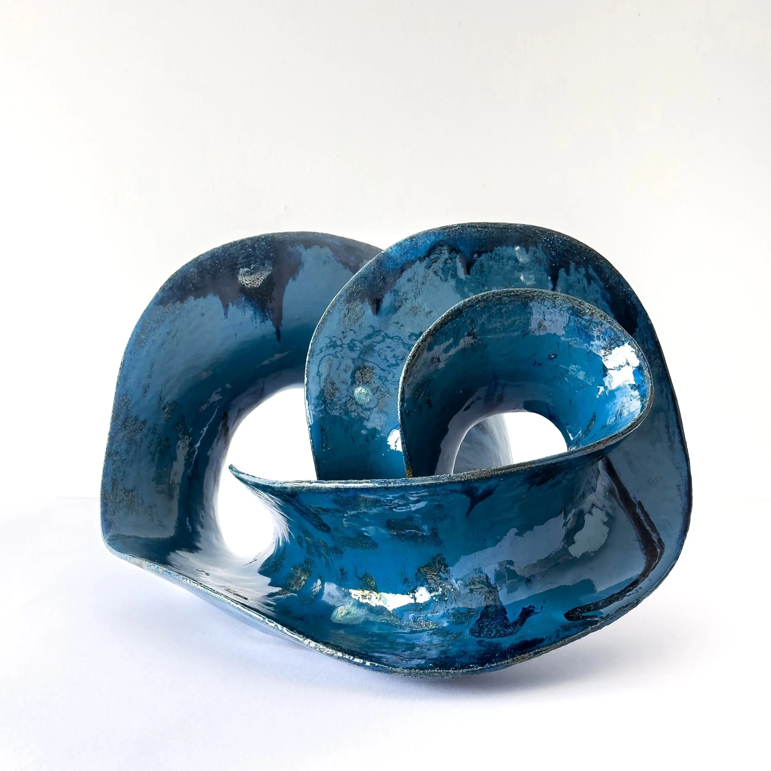 Ocean Sounds blue ceramic sculpture by Vânia R. Gonçalves, shaped as layered wave-like curves.