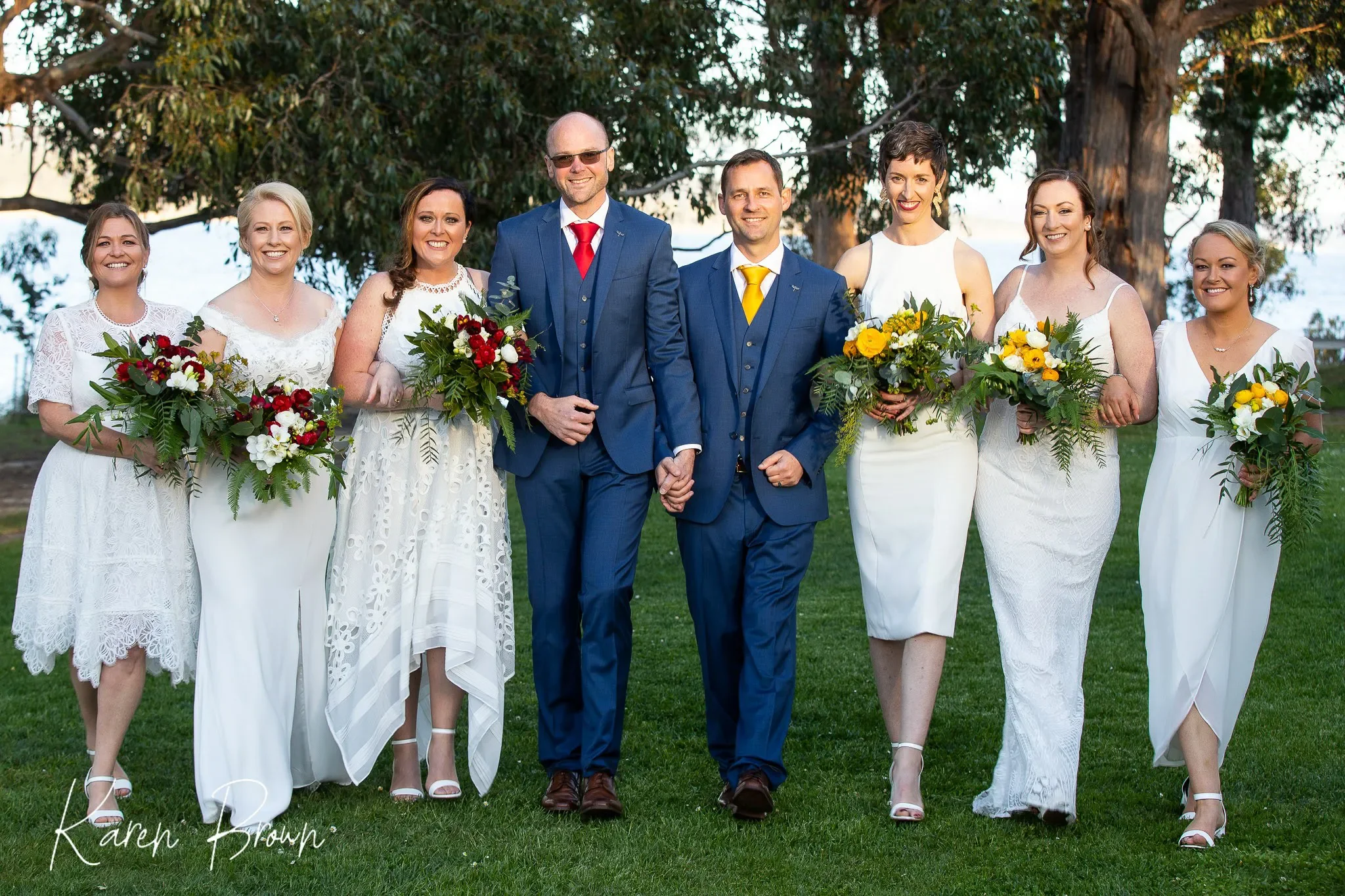 Group of wedding people walking on grass with flowers, outdoors