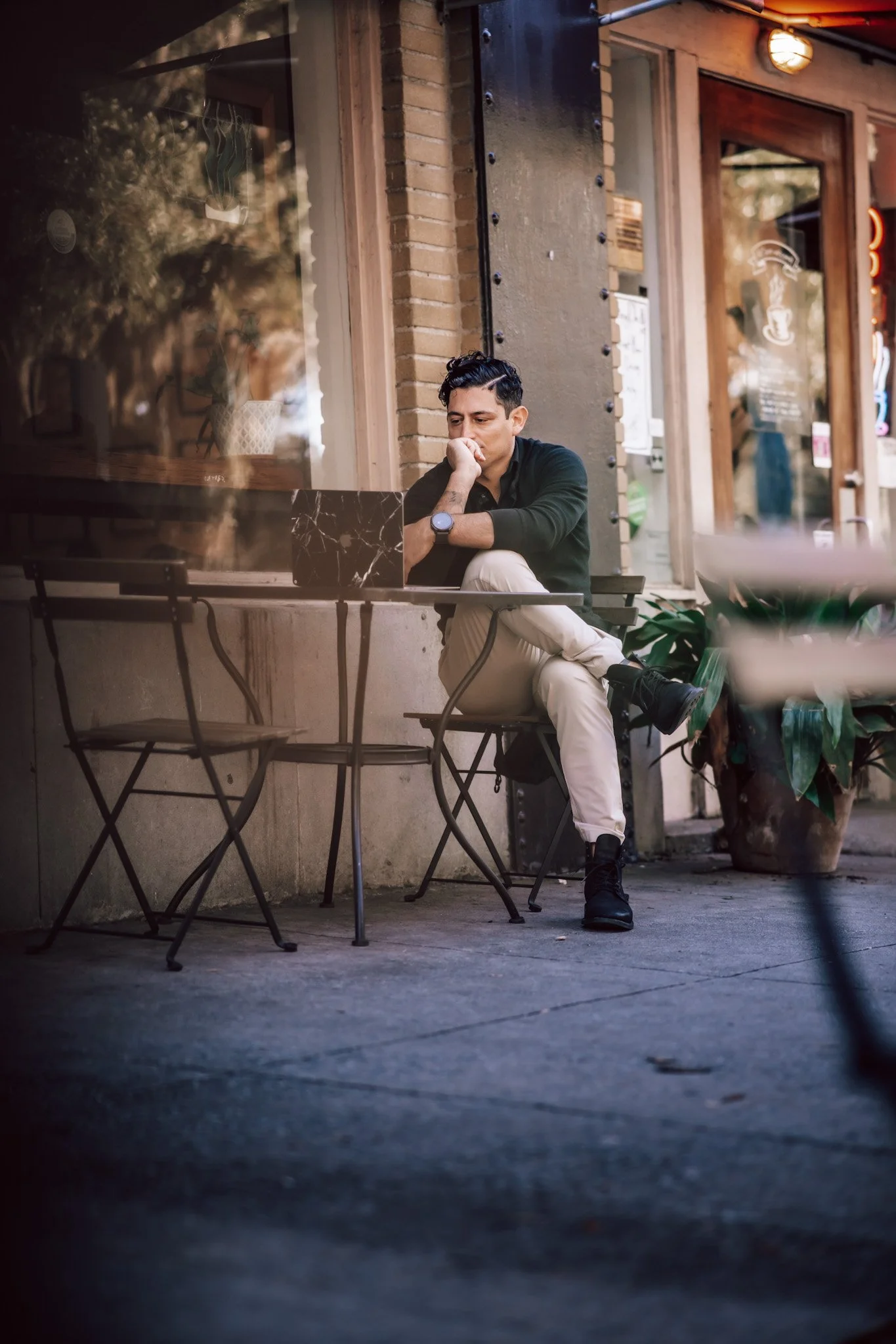 Alex Rodino leadership author sitting outdoors at a café table in a reflective working moment