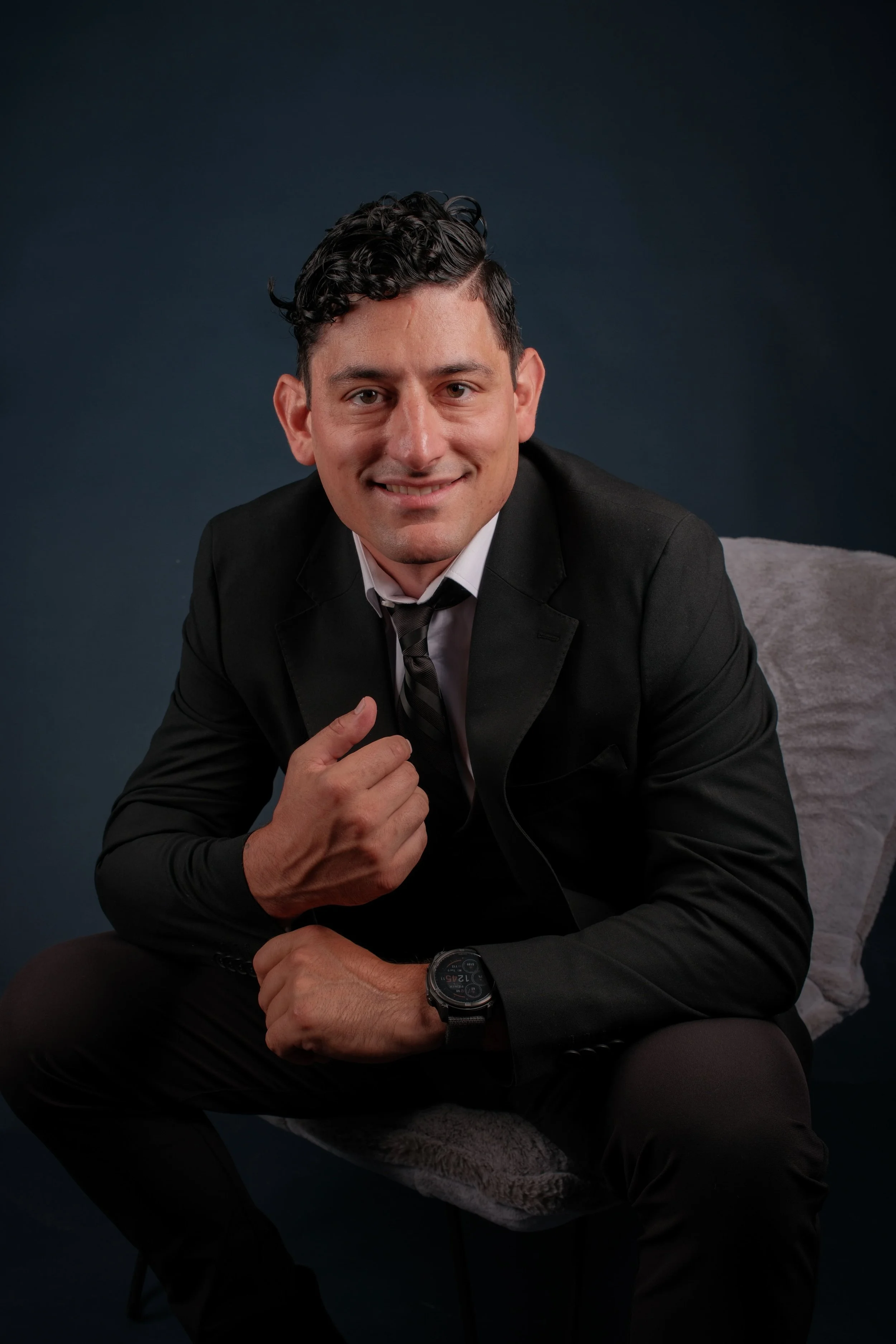 Alex Rodino, founder of Rodino Creative Works, photographed in a black suit — representing leadership built through pressure and guided by purpose.