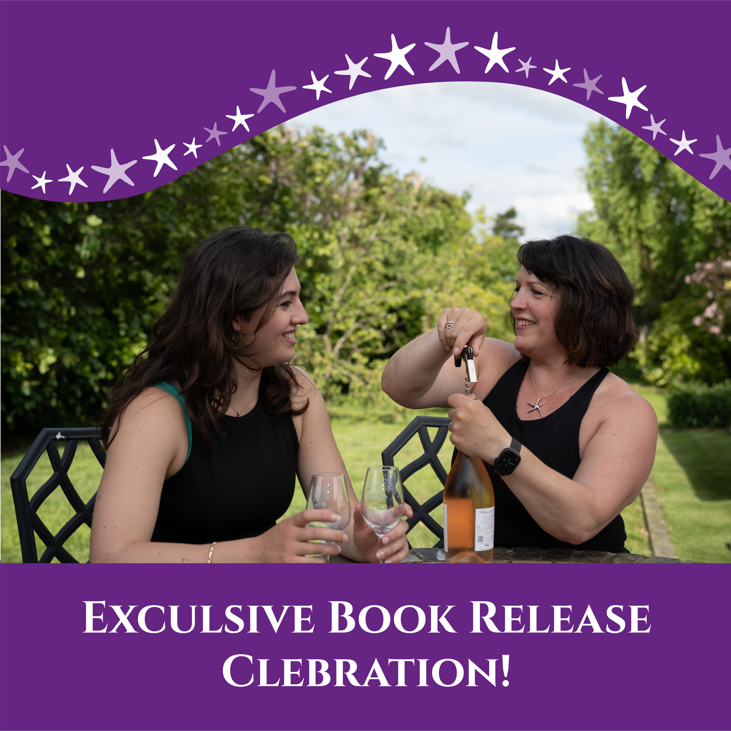 Co-directors Sara & Jenny sitting at a table outdoors, Sara opening the bottle of wine, ready to celebrate a book release with glasses on the table, surrounded by green trees.