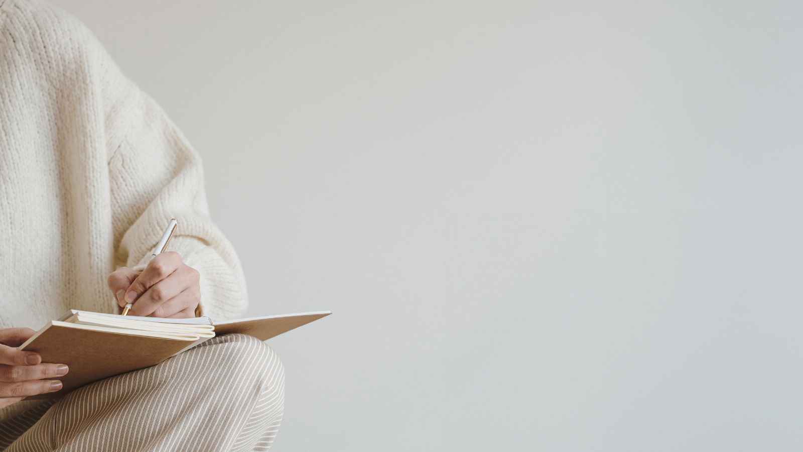 Person writing in a notebook, symbolising reflective therapeutic, hypnotherapy, and coaching support