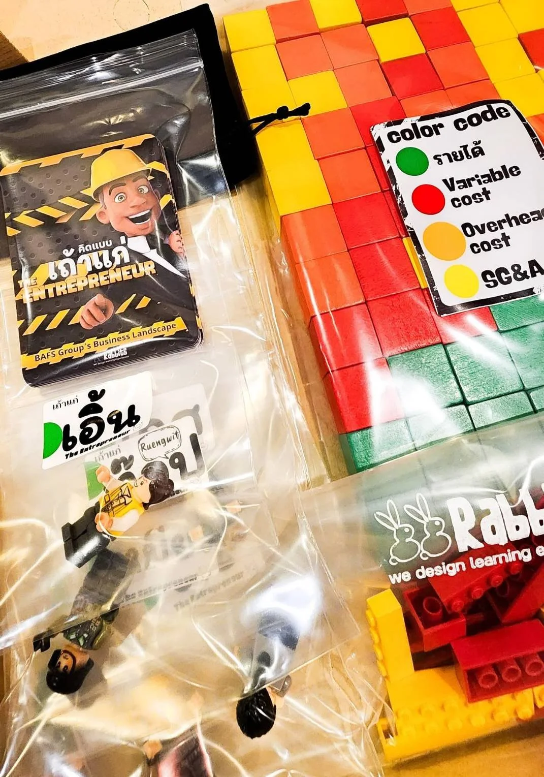 Assorted colorful building blocks and LEGO pieces with a color code chart are used in a learning mechanism for the Finance for Non-finance courses