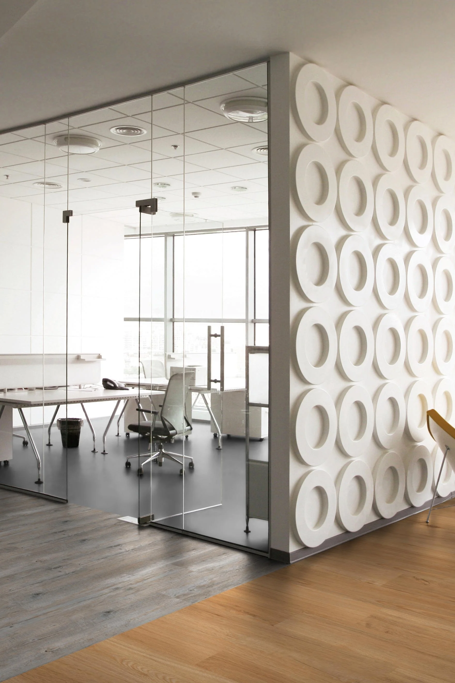 Moderne Büro mit Glaswänden, weißen Möbeln und einer dekorativen weißen Wand mit kreisförmigem Muster.