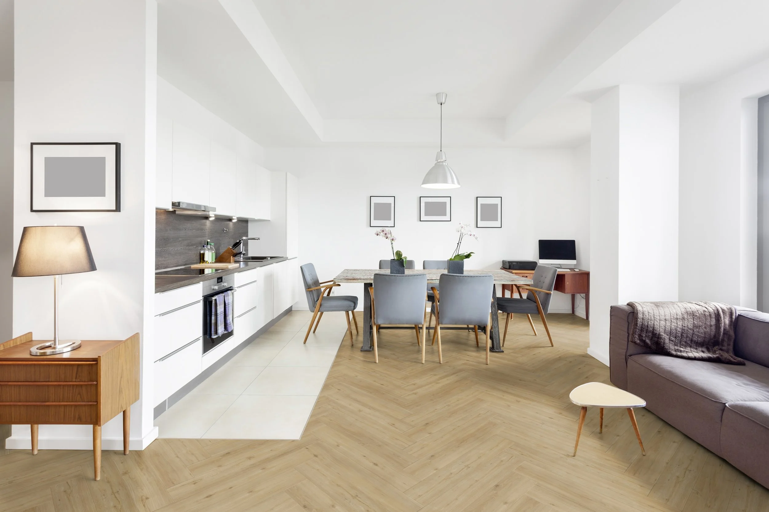 Modernes, offenes Wohnzimmer mit Essbereich und Küche, Holzboden, grauen Stühlen, weißen Wänden, dekorativen Bildern, Stehlampe, Sofa, kleinem Beistelltisch, Computer und nostalgischer Schreibmaschine