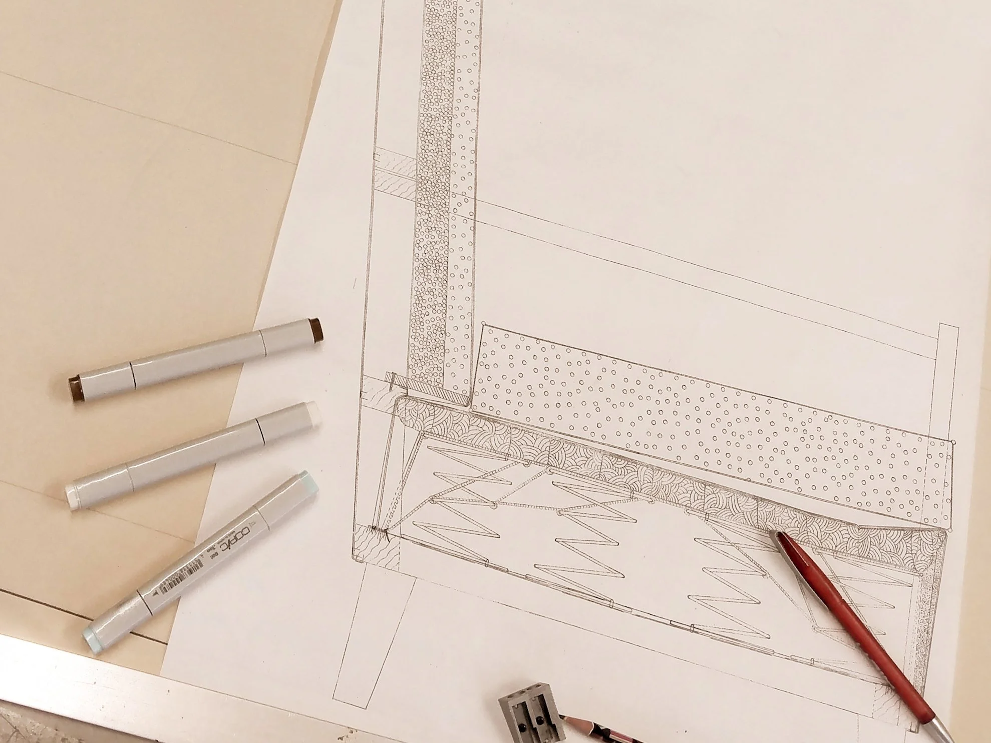 Architektenzeichnung eines Bauprojekts mit Markern, einem Lineal und anderen Zeichenutensilien auf dem Tisch.