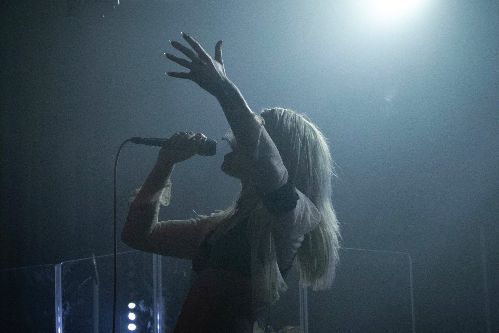 Female singing. dark shadow and spotlight on her.