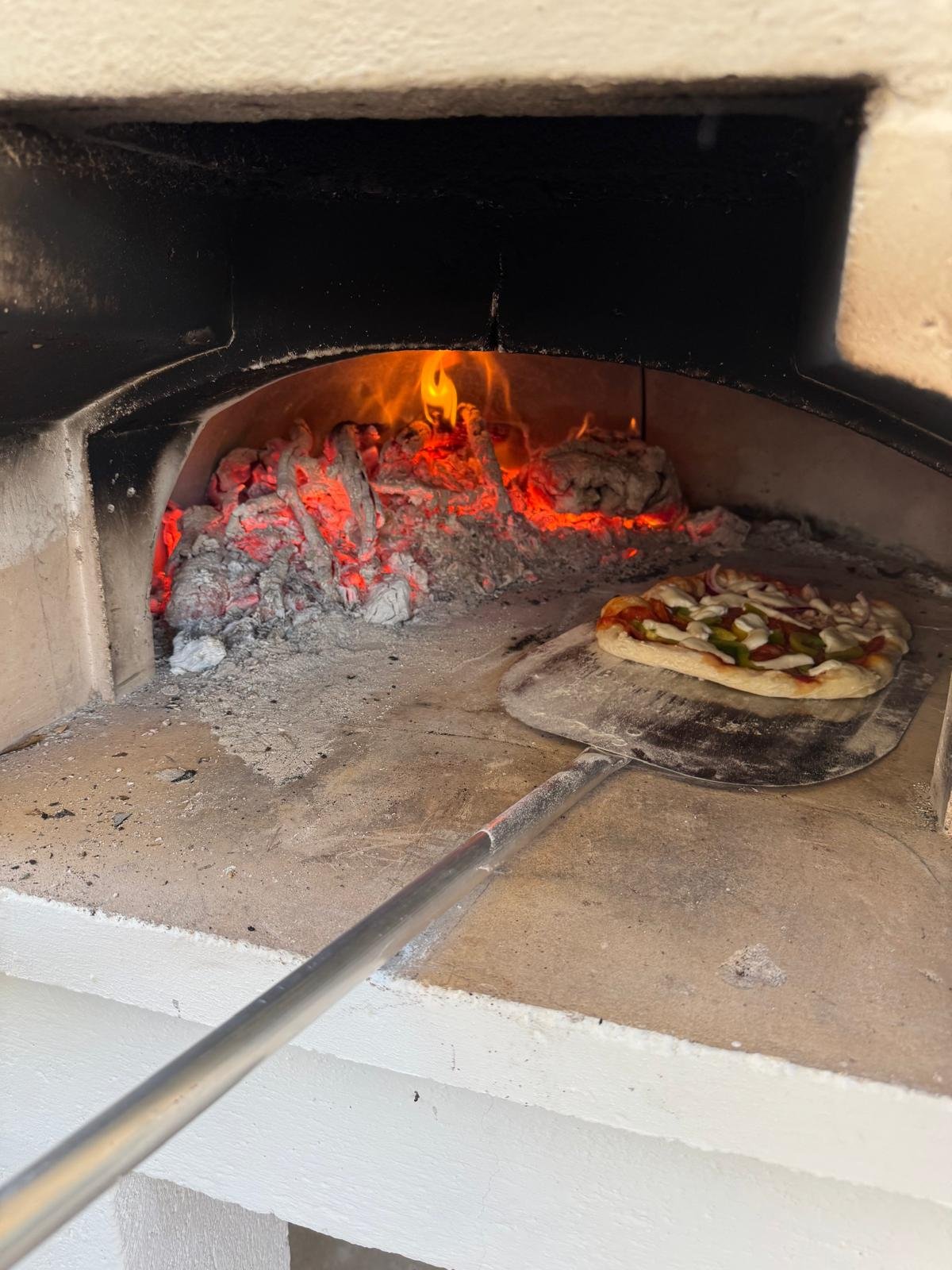 Pizza bakker in een houtoven met gloeiende houtskool