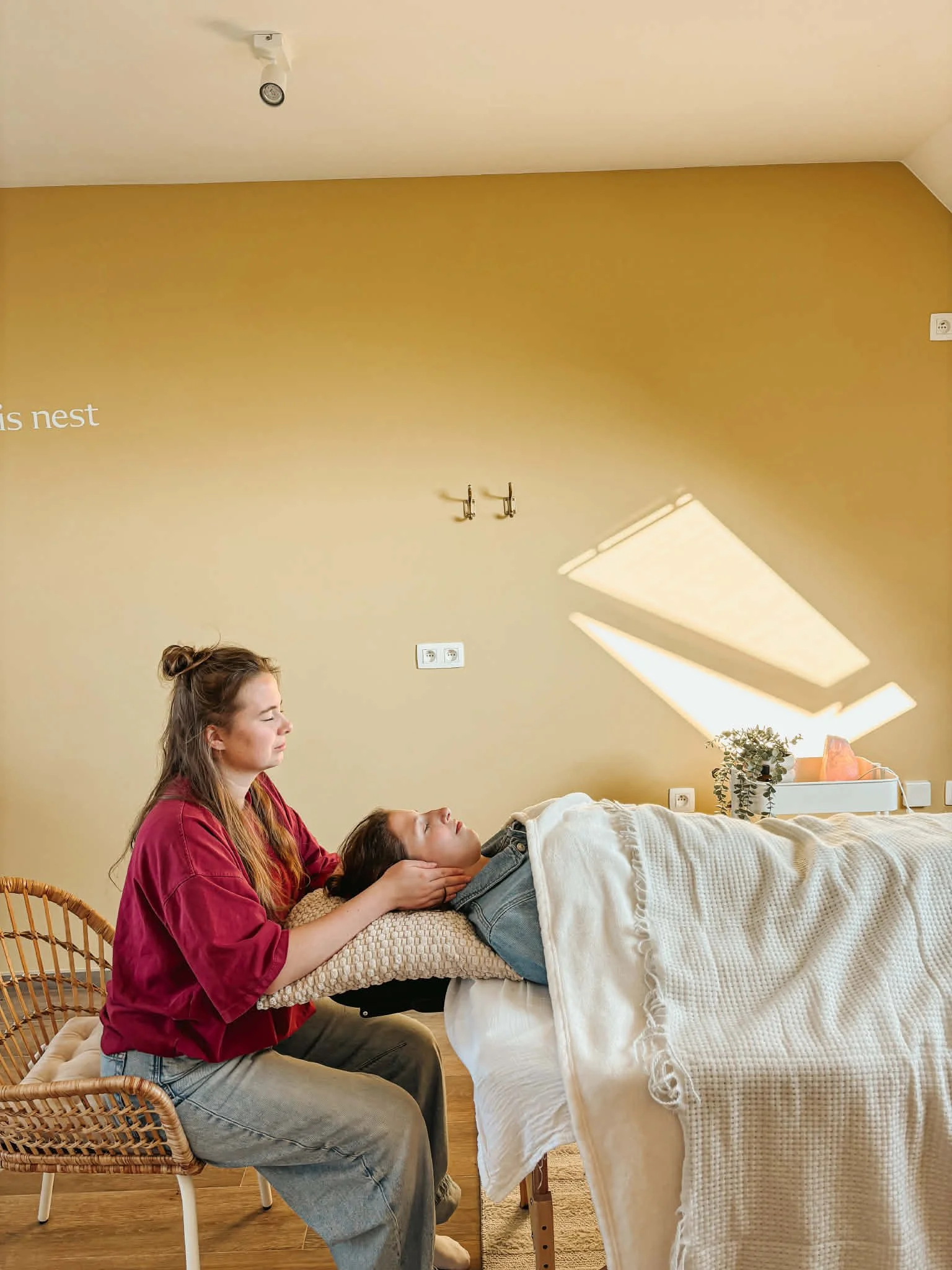 Vrouw liggend op massagetafel geeft reiki