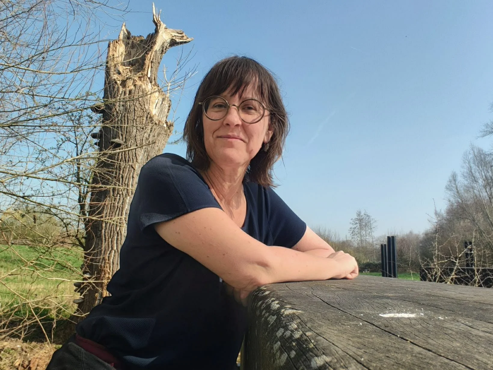 Lachende vrouw met bril, zittend in de zon