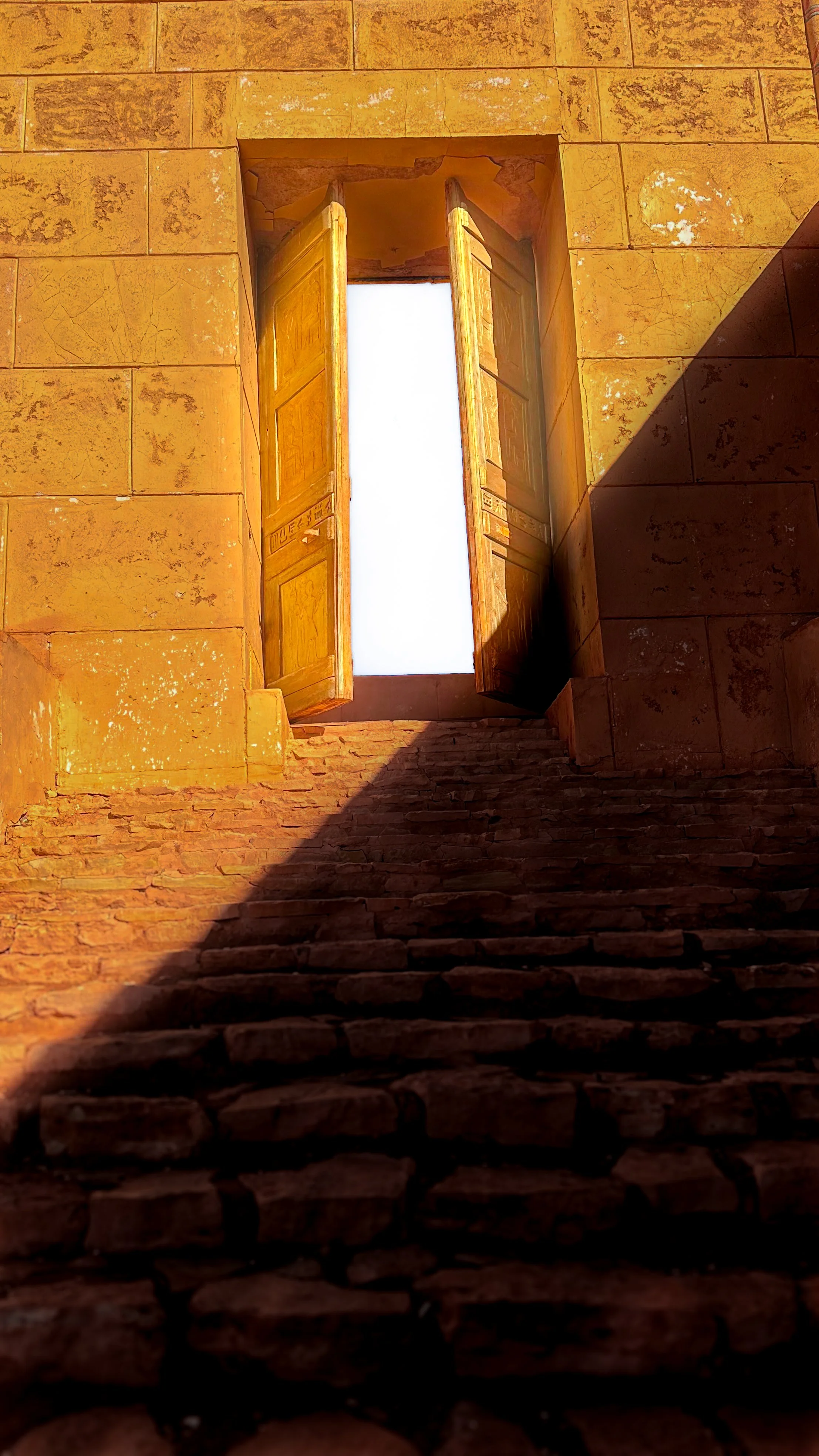 Stone staircase leading up to an open wooden window in a yellow stone building, with sunlight casting shadows.