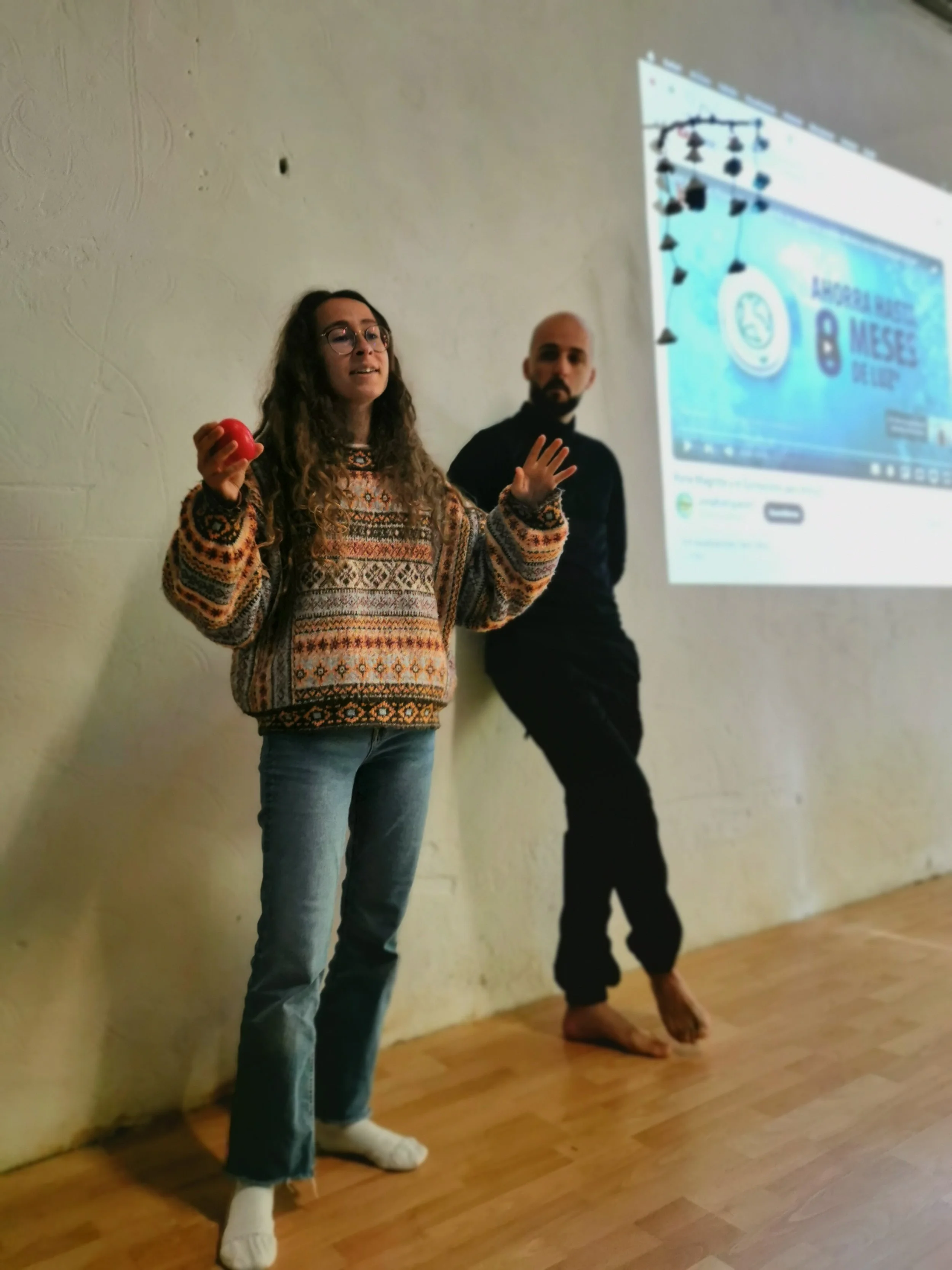 Una joven habla al resto del grupo. Tiene un compañero al lado que la mira. 