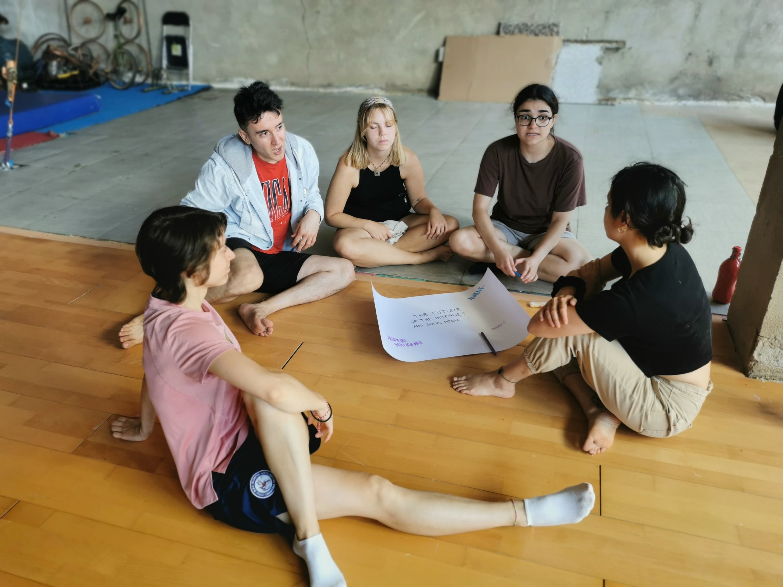 Un equipo de cinco jóvenes trabajan juntos. 