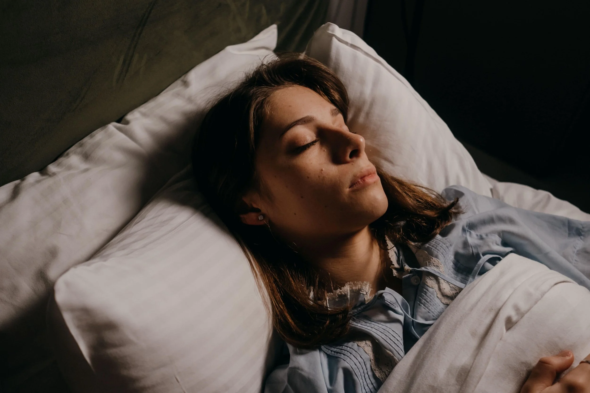 Woman in deep sleep, illustrating how slow-wave NREM sleep activates the glymphatic system to clear toxic proteins from the brain