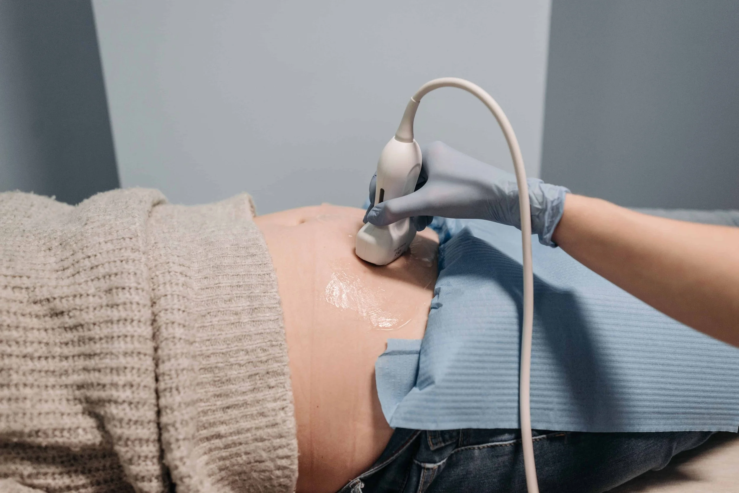 linician performing a pelvic ultrasound to evaluate the ovaries during PMOS diagnosis