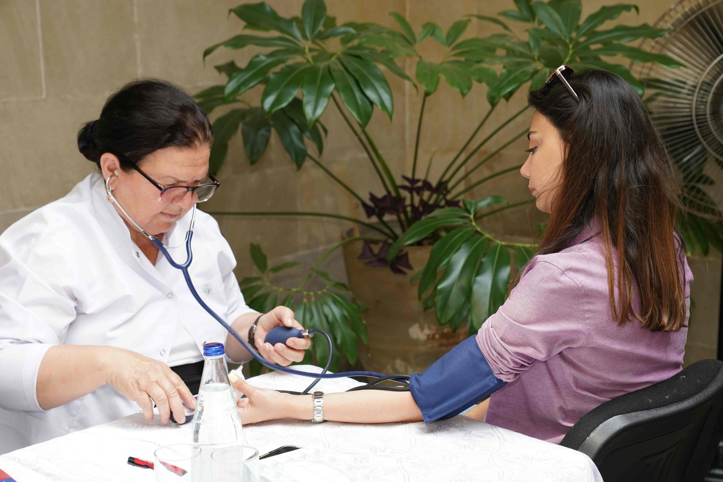 Female physician taking a patient's blood pressure during a personalized women's health consultation focused on root-cause medicine