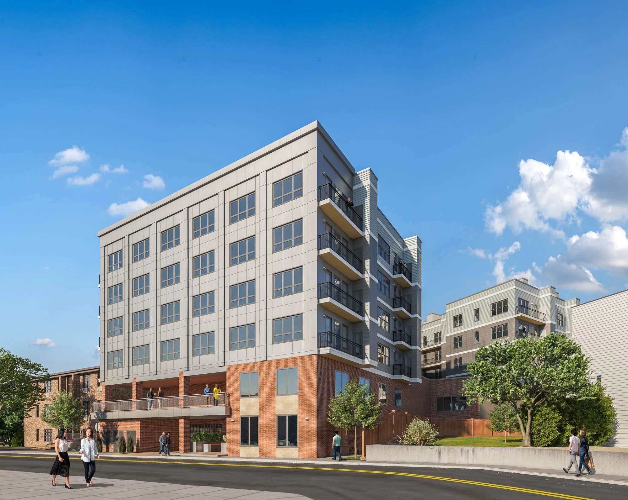 Modern multi-story residential building with a brick base, multiple balconies, and large windows, along with trees, on a sunny day with a blue sky and some clouds.