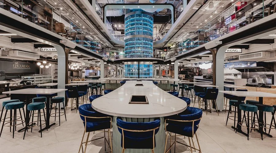 Modern restaurant with a bar area, seating, a food vehicle, and wall signs.