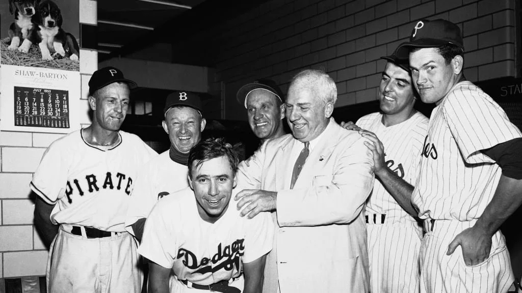 Vintage black and white photo of Pirates and Dodgers players in the clubhouse