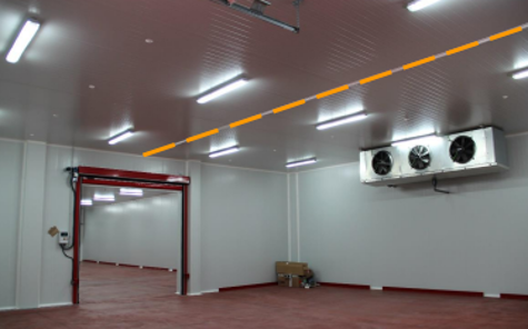 Empty industrial or commercial room with white walls, red trim, and ceiling, and HVAC units on the wall.