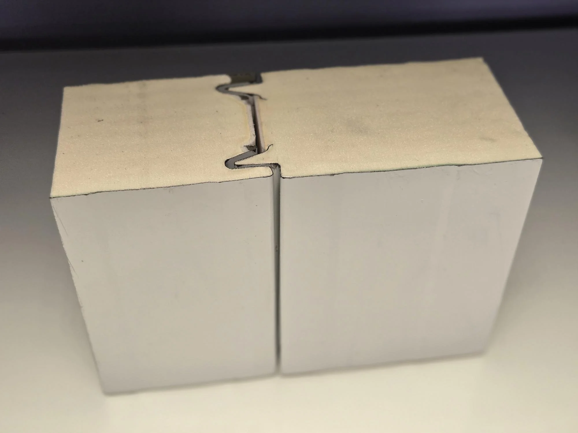 A cardboard box with interlocking tabs on top, placed on a flat surface.