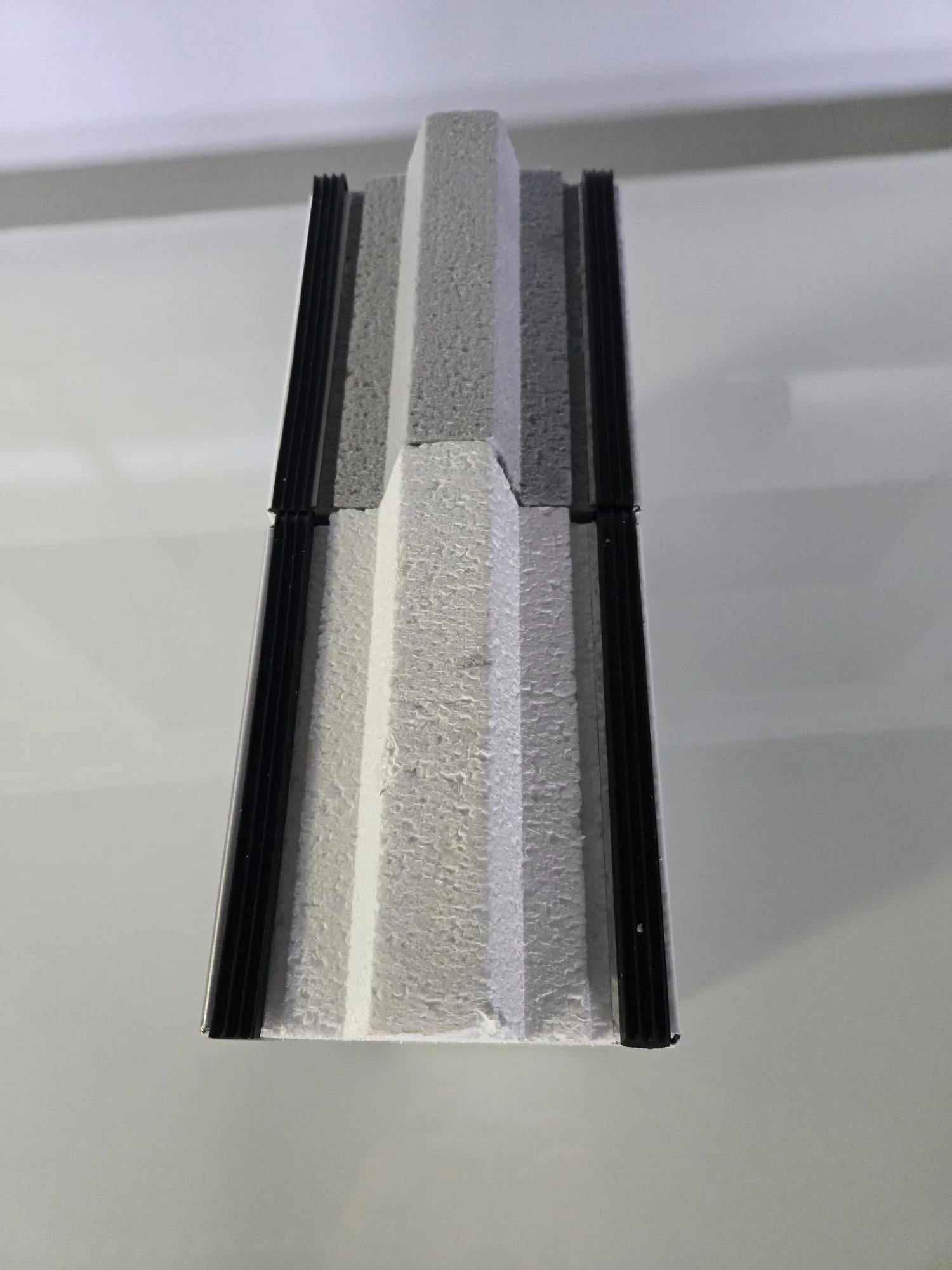 Cross-section view of various insulations and wall materials layered with black framing strips.