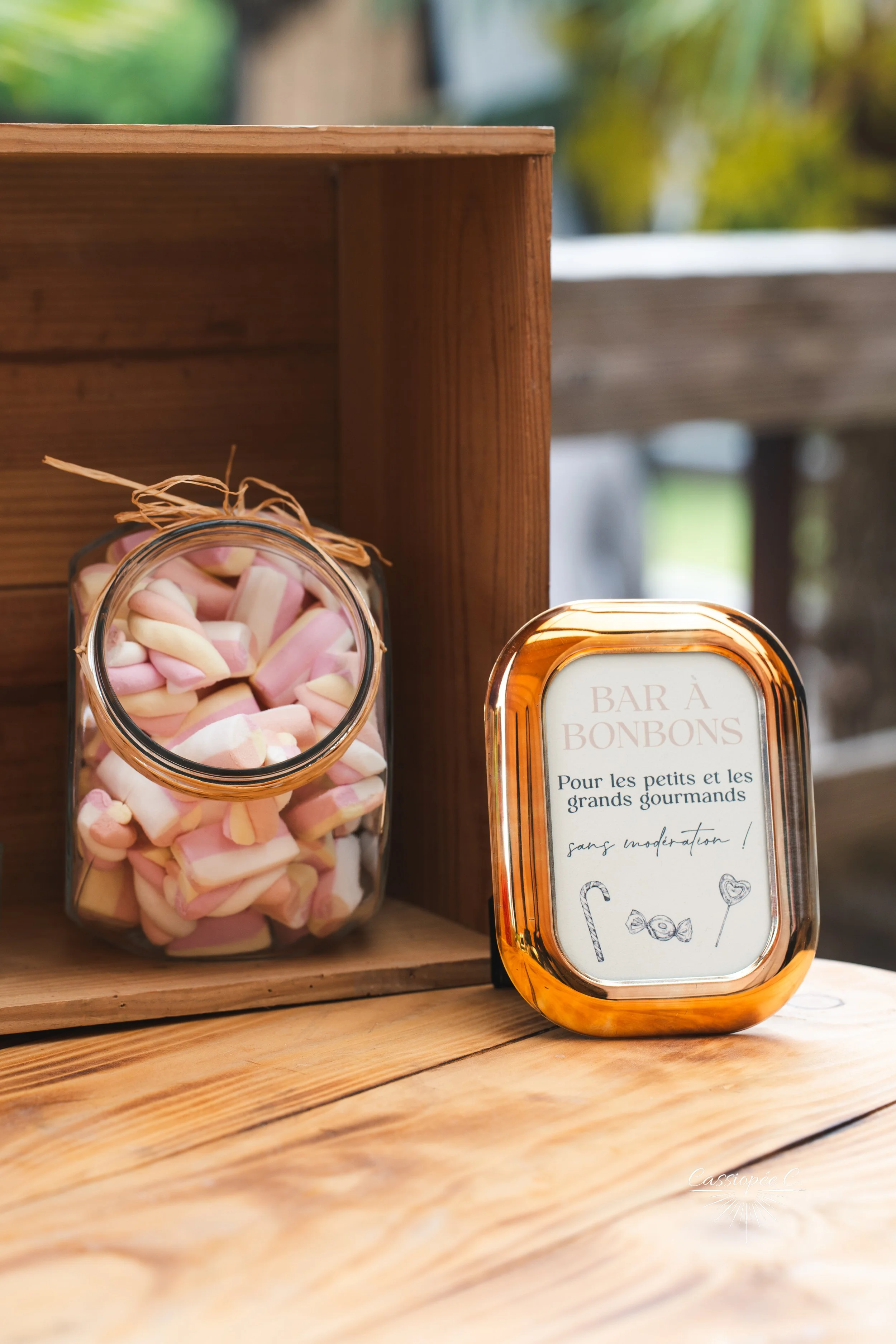 Pot de bonbons colorés, rose, blanc et beige avec étiquette ‘Bar à Bonbons’ pour enfants et grands gourmands, décor en bois naturel.