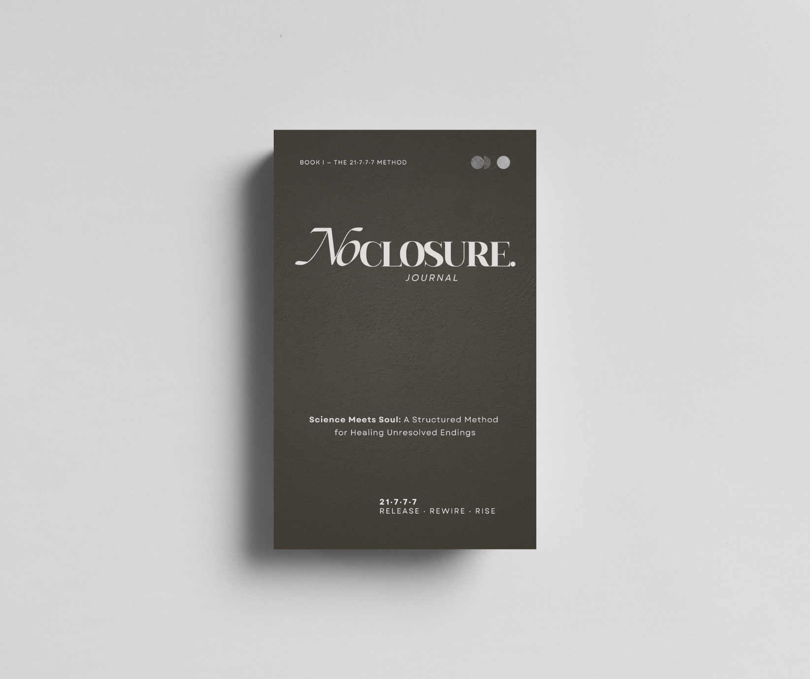 A dark gray journal cover titled 'No Closure'. Subtitle reads 'Science Meets Soul: A Structured Method for Healing Unresolved Endings'. Small text at the top says 'Book 1 - The 21.7.7.7 Method'. Bottom text states '21.7.7.7 Release, Rewire, Rise'.
