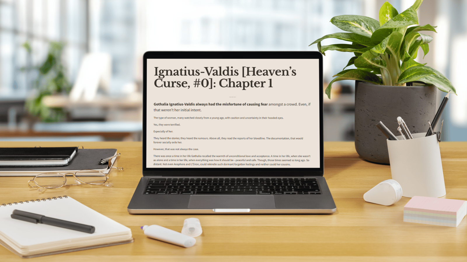 Open laptop on a wooden desk displaying a book titled 'Ignatius-Valdis [Heaven's Curse, #0]: Chapter 1' with office supplies and a potted plant around it.