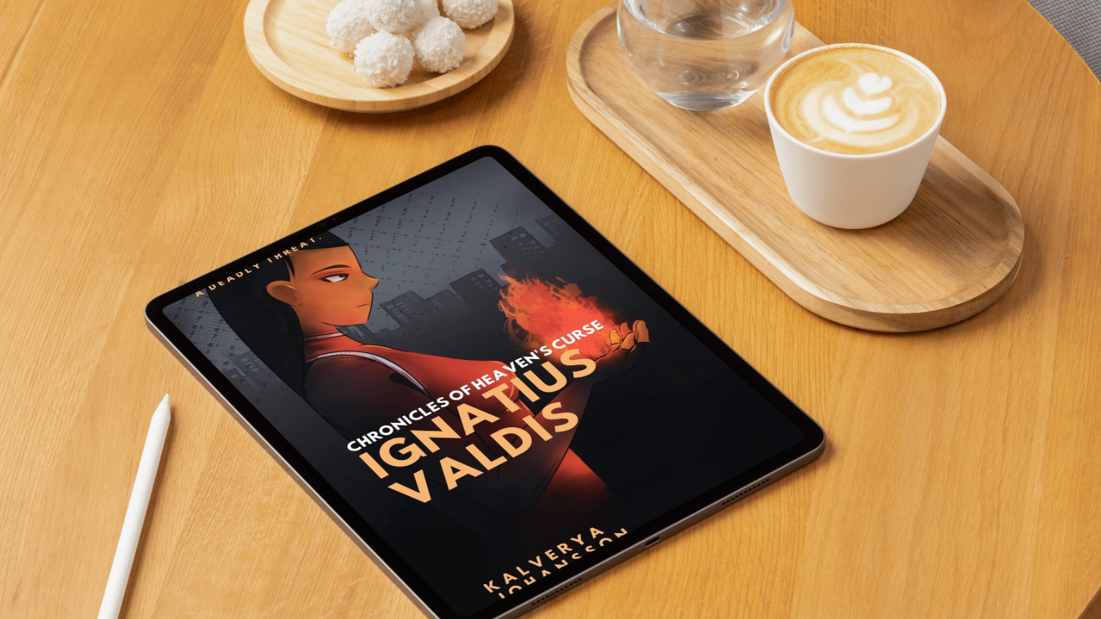 A tablet displaying the cover of a book titled "Ignatius Valdis: Chronicles of Heaven's Curse" on a wooden table. The cover features an animated woman with dark hair and a serious expression, holding a flame-shaped object with a cityscape in the background. Nearby, there is a white stylus, a glass of water, a cup of latte with latte art, and a wooden tray with a glass of water and a bowl of coconut-covered treats.